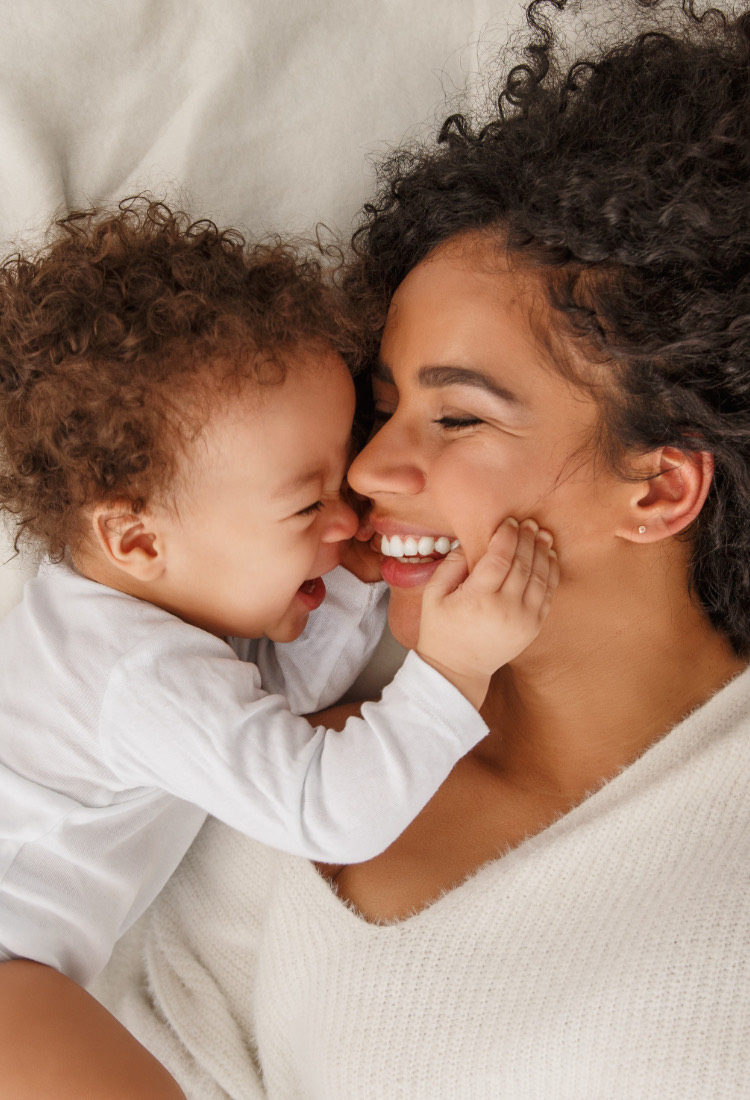 A mother nose to nose with her laughing baby